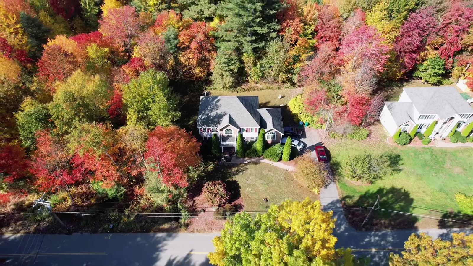 Aerial drone shot of a home surrounded by fall foliage